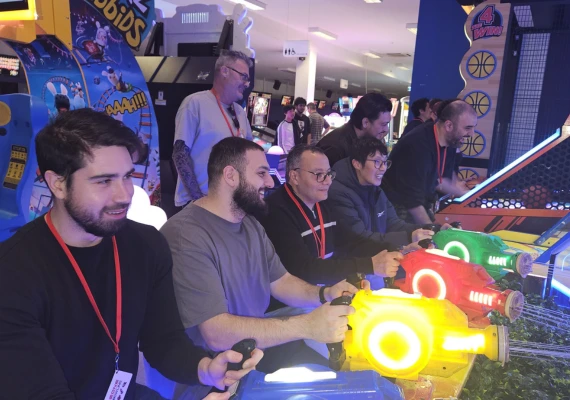 Rapid team members playing arcade games at a team social